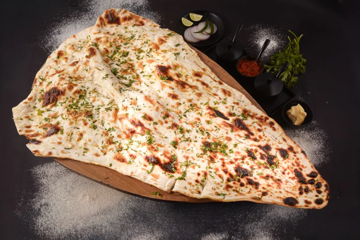 Oversized stuffed naan on a copper thali